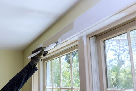 Le pinceau est utilisé pour peindre les moulures de fenêtre avec de la peinture blanche