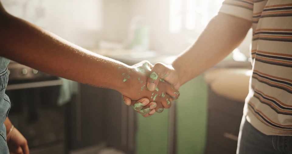 Gros plan sur un peintre avec un outil de brosse recouvert d'un mur de peinture bleu