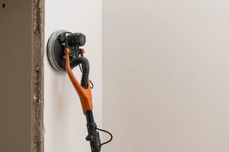 En utilisant le pinceau pour toucher le plafond avec de la peinture blanche, le peintre de maison peint la surface